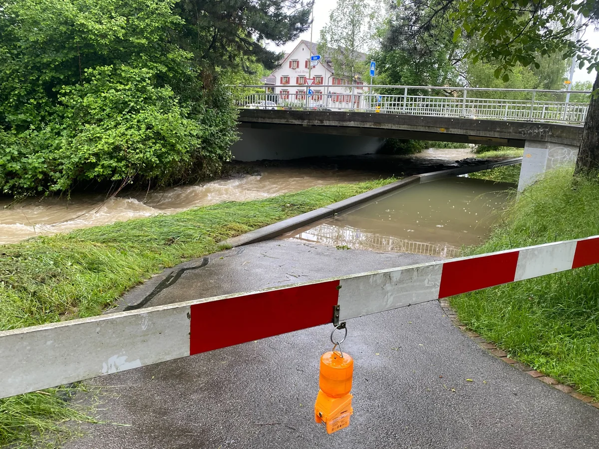 Eine Unterführung neben einem Bach, die unter Wasser steht.
